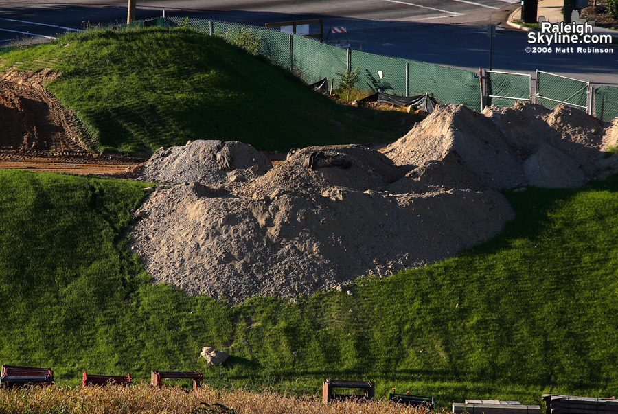 Green grass grows on a pile of construction dirt.