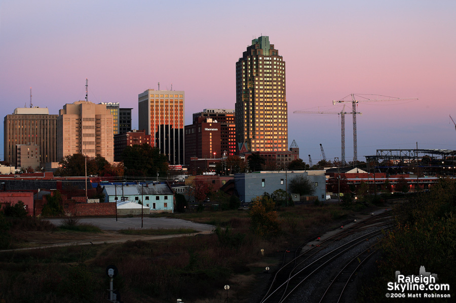 Sun setting on Raleigh from Boylan Avenue with construction cranes.