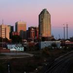 Sun setting on Raleigh from Boylan Avenue with construction cranes.