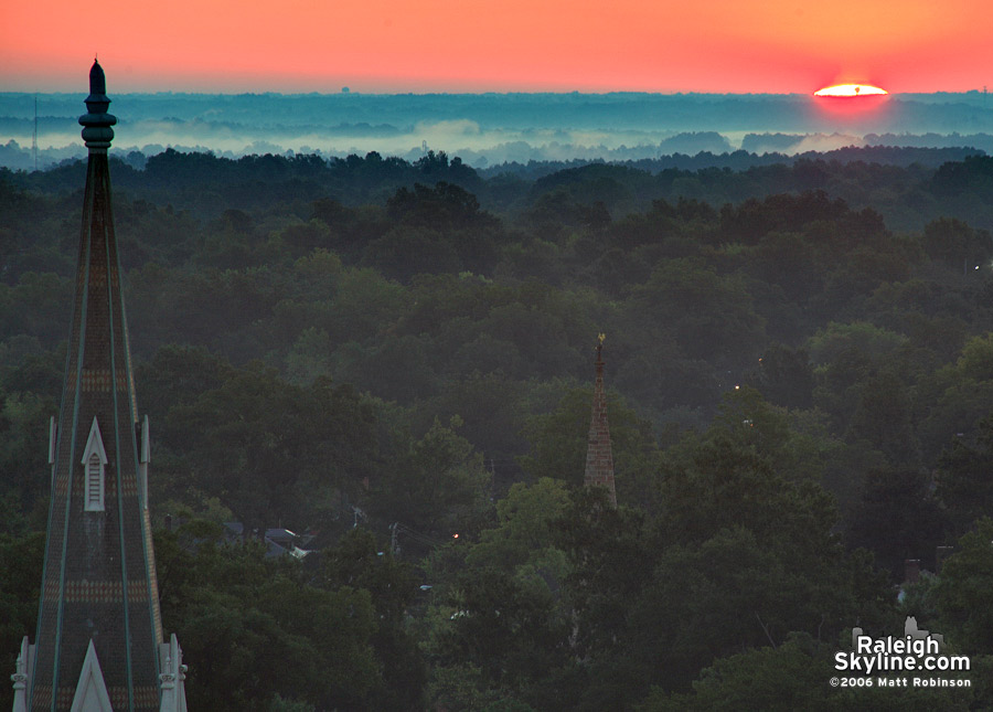 The rising sun and a church steeple.