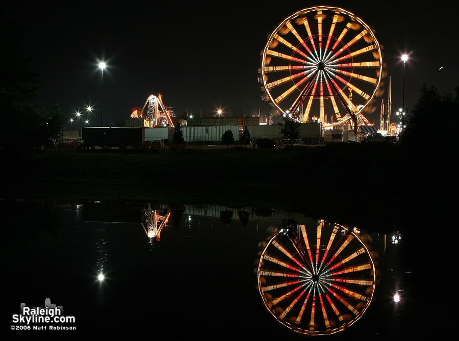 Night time ferris wheel reflection.