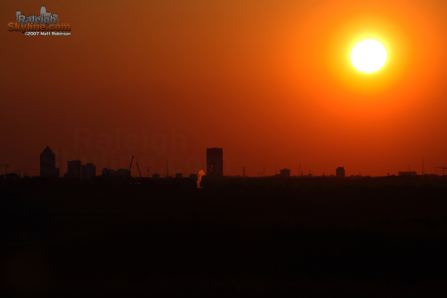 The sun silhouettes the Raleigh skyline.