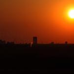 The sun silhouettes the Raleigh skyline.