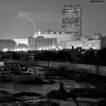 As a train rolls through downtown, lightning makes an appearance adjacent to Wachovia Capital Center.