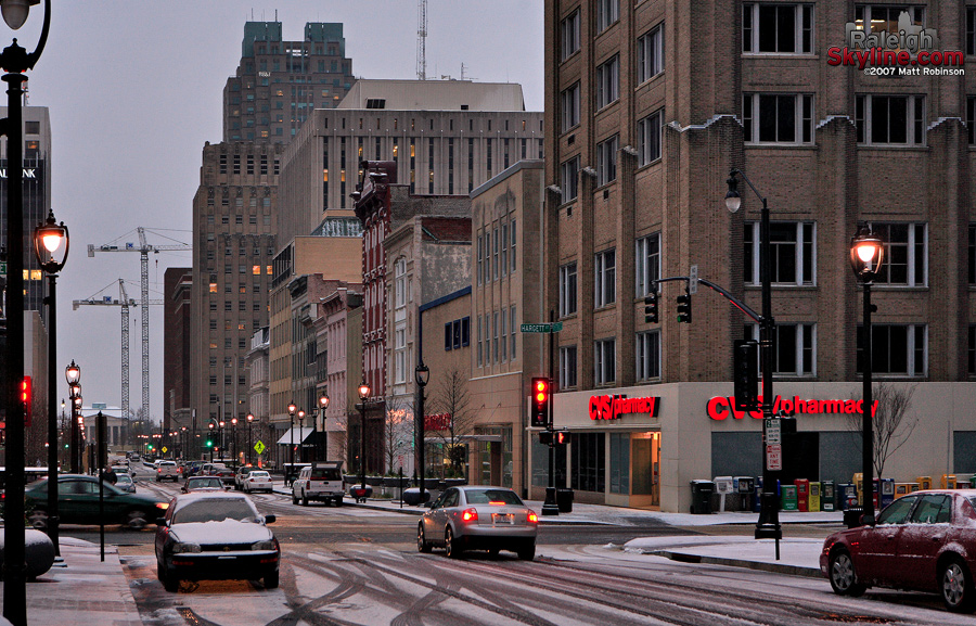 Snow lightly covers cars, sidewalks and Fayetteville Street in Downtown Raleigh.