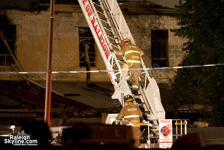 Raleigh Firemen descend ladder.