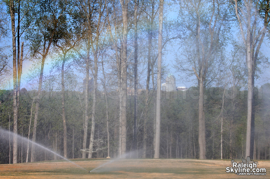 Rainbow in the sprinkler, with the skyline