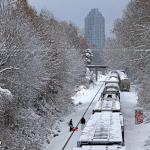 Snowy Norfolk Southern train passes snowboarders in Raleigh