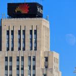 Daytime moonrise behind Durham's Hill Building (SunTrust Tower)