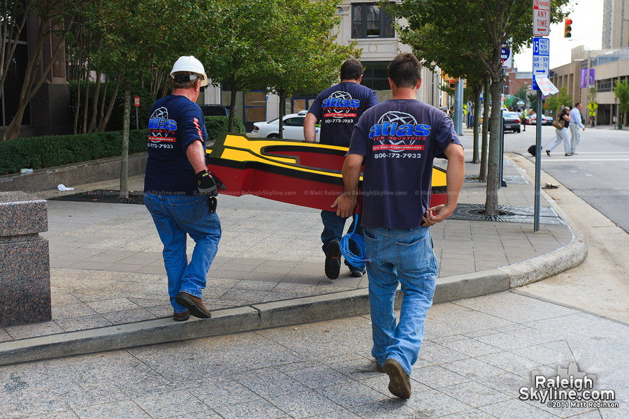 Signage workers carry a letter "G" for placement atop Raleigh's Skyline in Wells Fargo