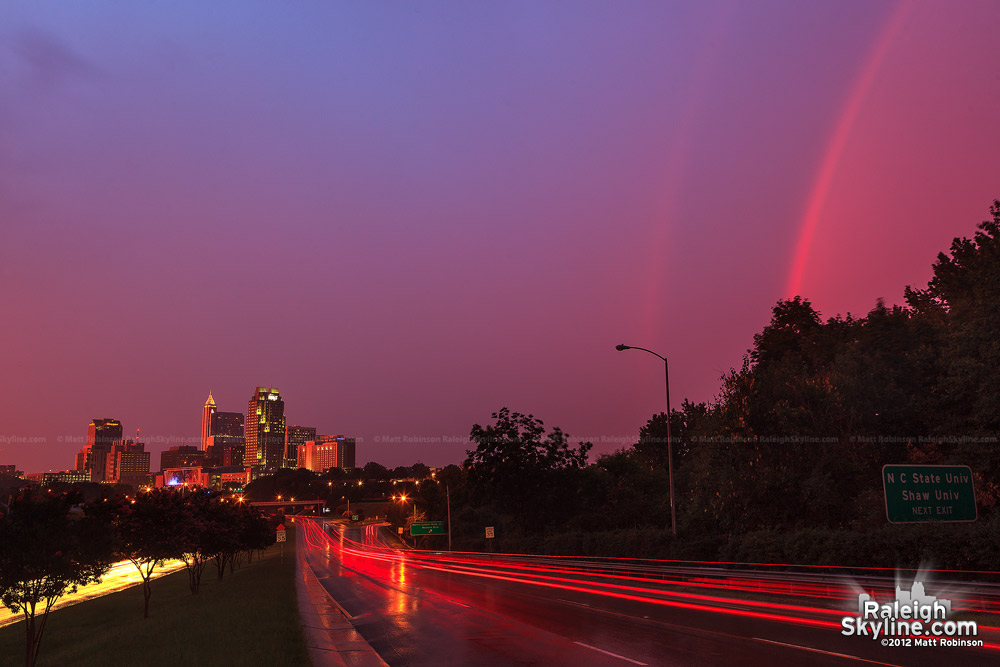 Surreal scene over Raleigh with rainbow and setting sun after a storm