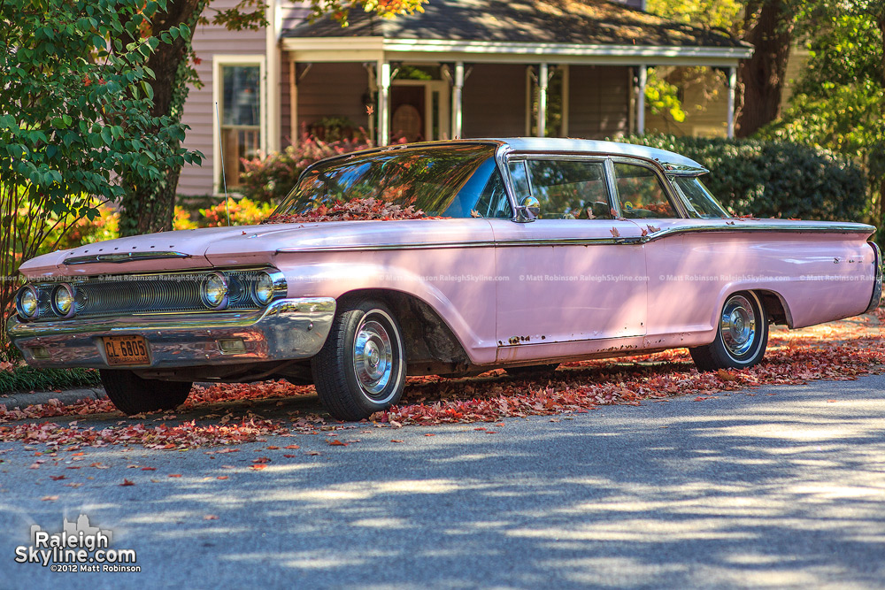 Pink 1960 Mercury Monterey surrounded by autumn leaves in Oakwood