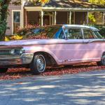 Pink 1960 Mercury Monterey surrounded by autumn leaves in Oakwood