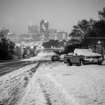 Black and White abandoned cars in the snow with Raleigh skyline