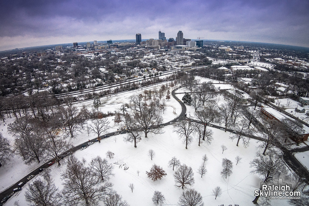 Aerial of sledding at Dorothea Dix with downtown Raleigh