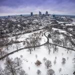 Aerial of sledding at Dorothea Dix with downtown Raleigh