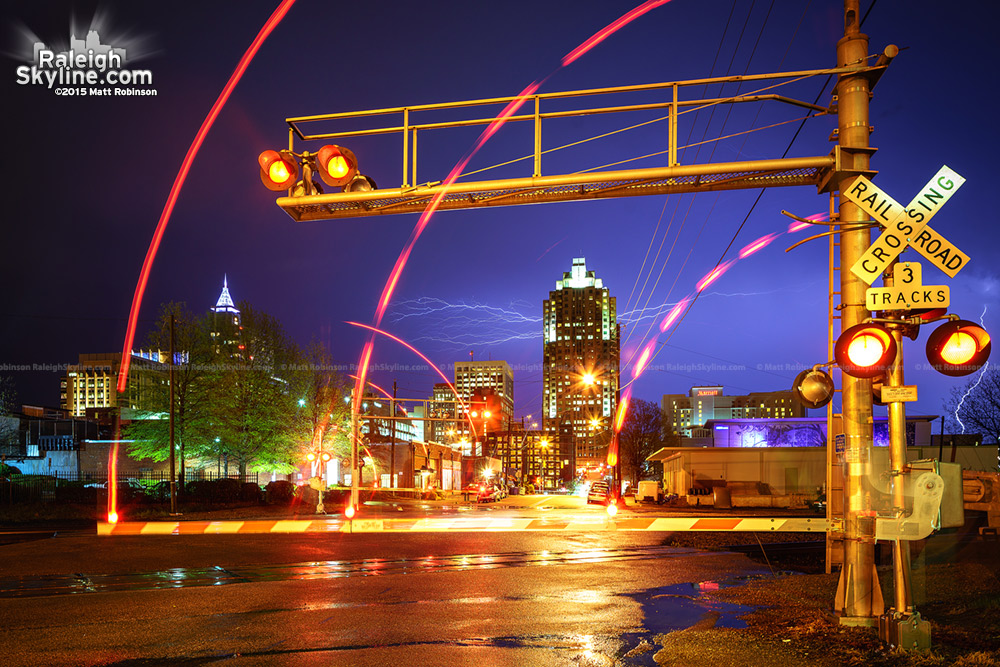 Lightning streaks over Raleigh with crossing gates from Amtrak