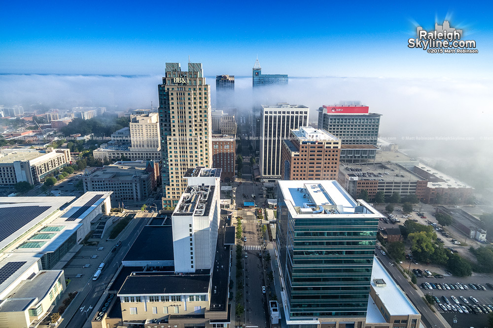 Fog ebbs between Raleigh Buildings