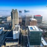 Fog ebbs between Raleigh Buildings