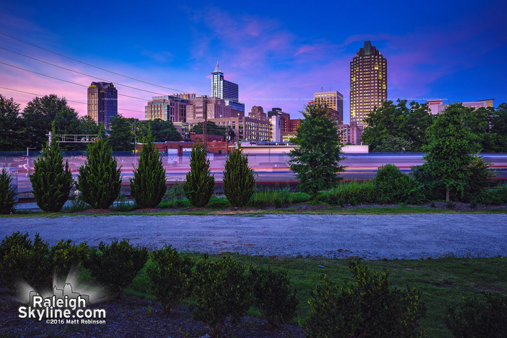 The ghost of the Amtrak train at sunset with downtown Raleigh