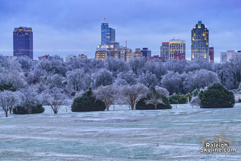 Raleigh rises over icy trees after the snowstorm at dusk