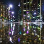 Puddles reflect Fayetteville Street