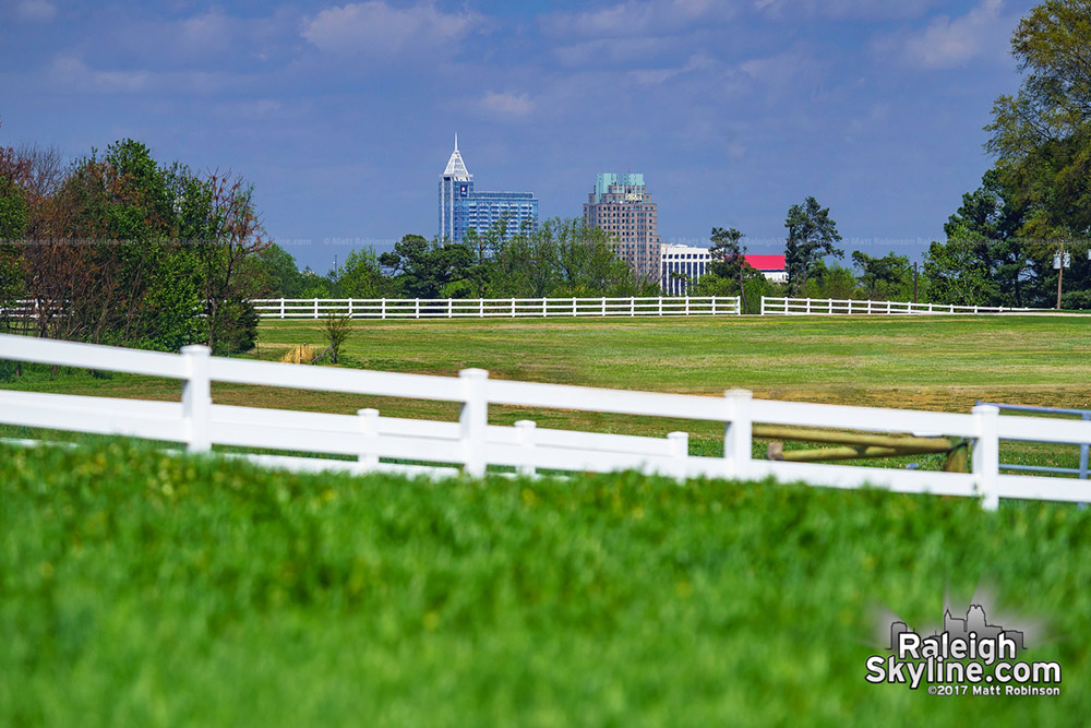 Downtown Raleigh appears among the gentle rolling hills of the NCSU Field Lab from Lake Wheeler Road