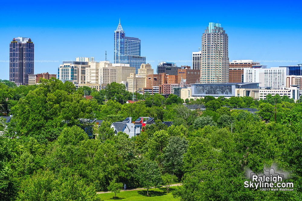 Downtown rises over the trees from Umstead Drive