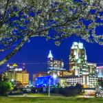 Downtown Raleigh twinkles under night time cherry blossoms