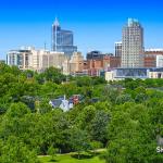 Downtown rises over the trees from Umstead Drive