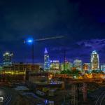 Distant lightning lights up a storm behind downtown at night from Boylan