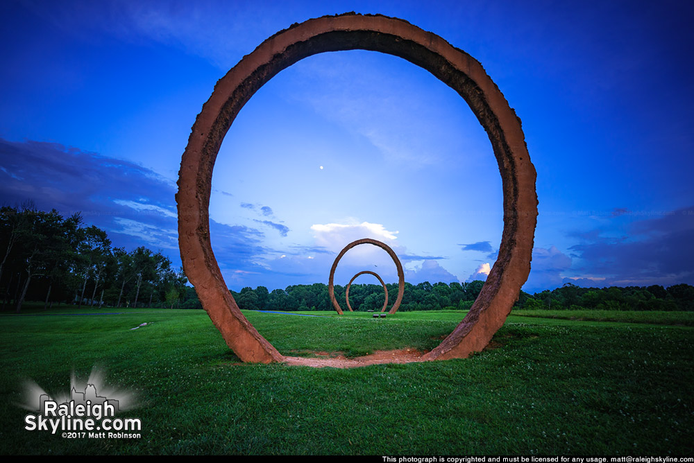 Giant rings at North Carolina Museum of Art with the moon after sunset