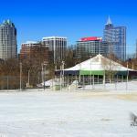 Chavis Park carousel in the snow with the Raleigh Skyline