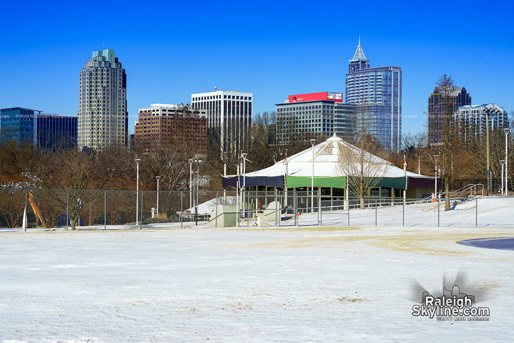 Chavis Park carousel in the snow with the Raleigh Skyline