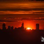 Sun dips behind the silhouette of downtown Raleigh skyline