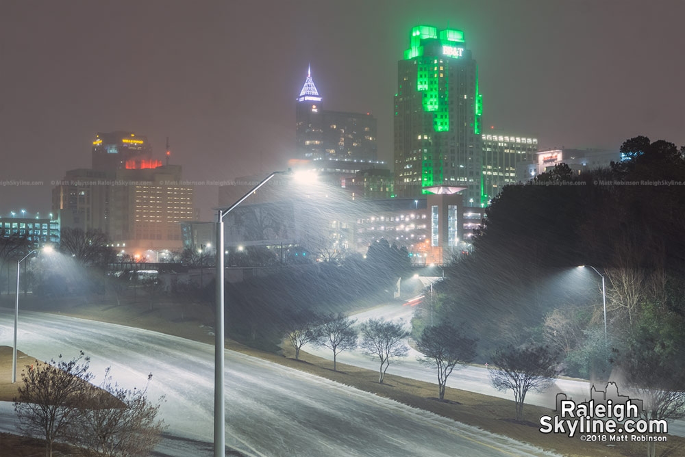 Snow falling with the Raleigh skyline