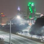 Snow falling with the Raleigh skyline