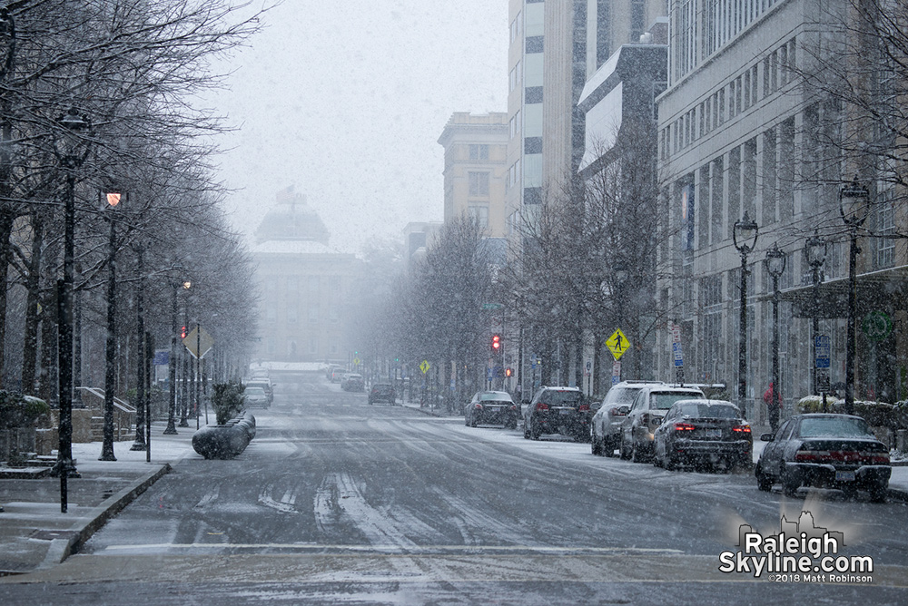Early flakes obscure the NC State Capitol from Fayetteville Street