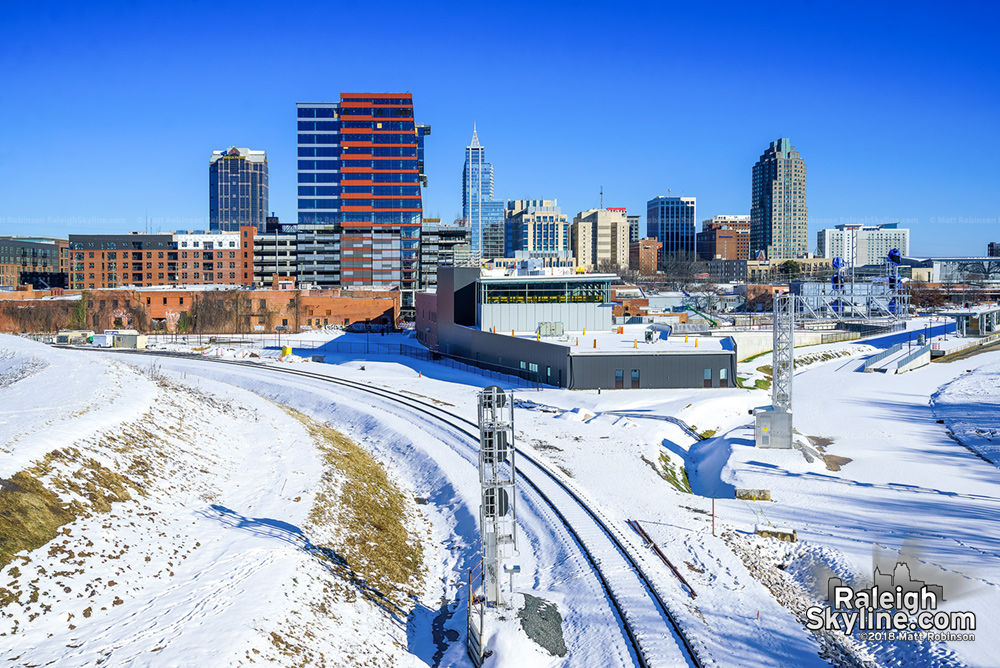 Blue skies with snow and downtown Raleigh skyline