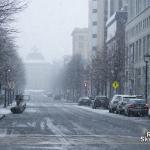 Early flakes obscure the NC State Capitol from Fayetteville Street