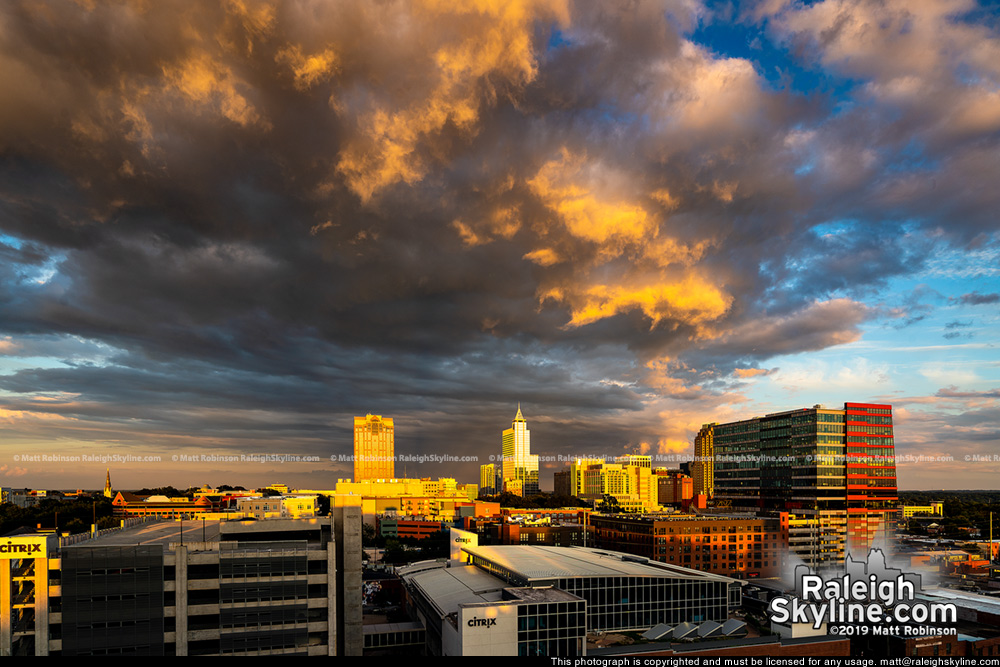 Sunlight underneath clouds with downtown Raleigh