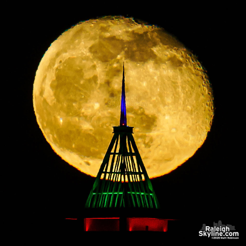 Moon rise behind the crown of Christmas tree PNC Plaza.