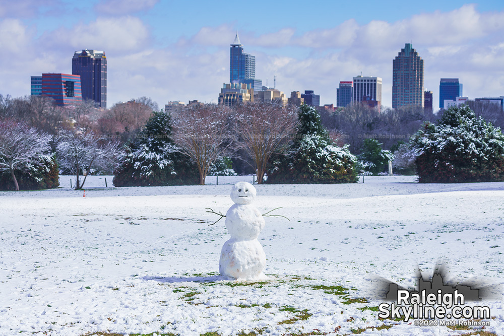 Snowman at Dix Park with downtown Raleigh skyline