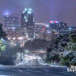 Snow covered trees with downtown Raleigh