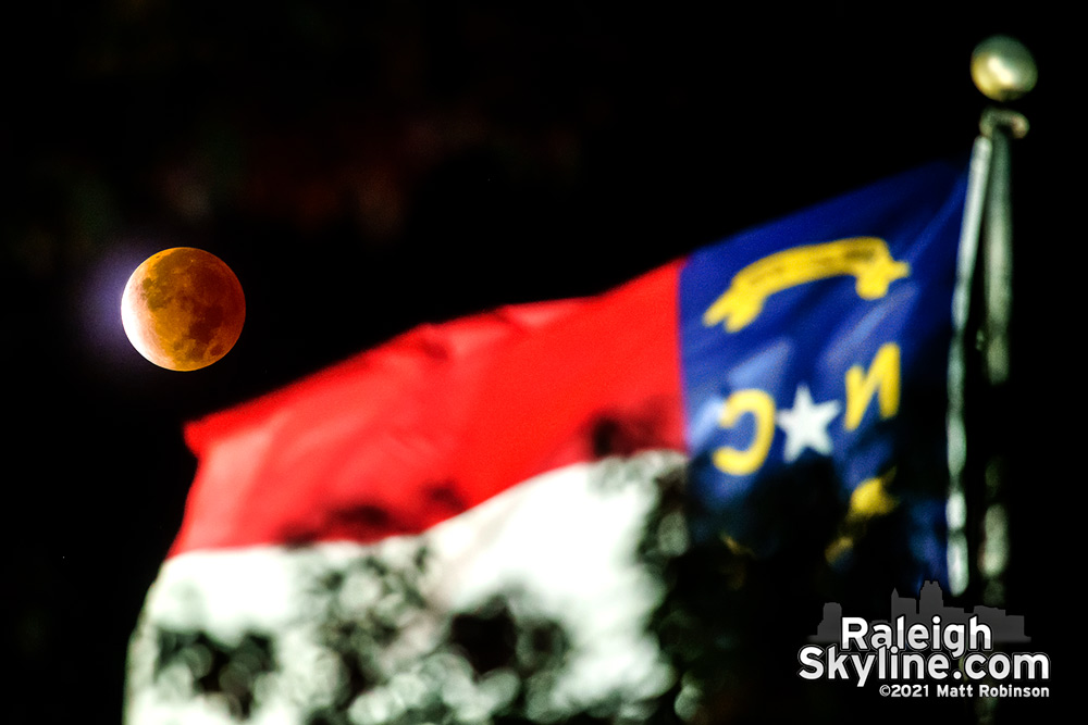 The red moon and the North Carolina flag atop the Capitol building in Raleigh blowing in the early morning wind during the lunar eclipse.