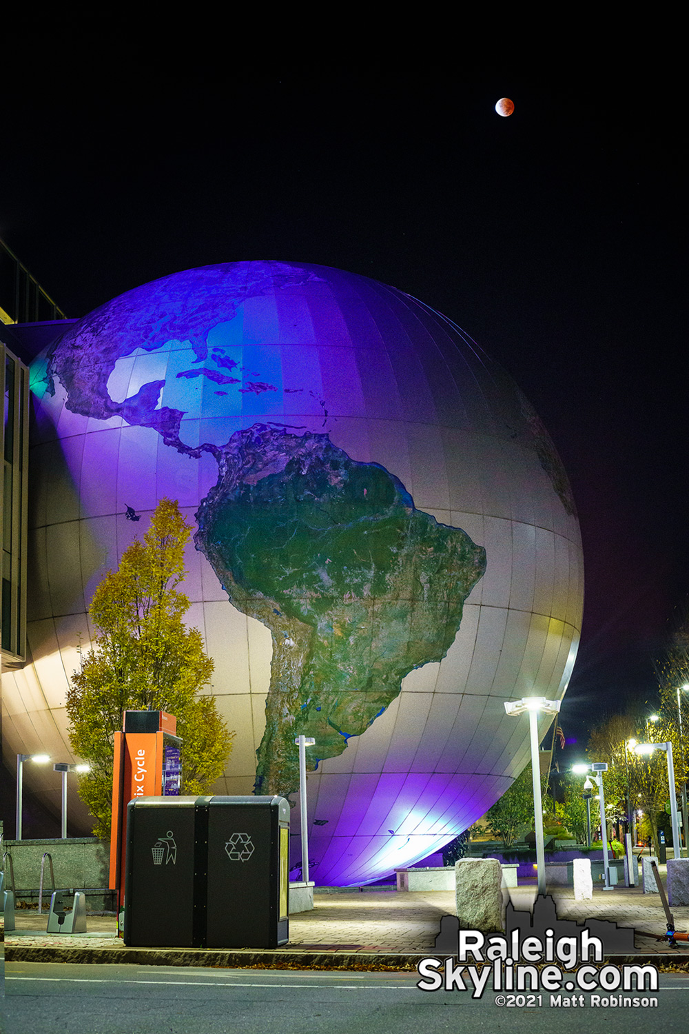 The Eclipsed moon setting over the Daily Planet at the Nature Research Center in downtown Raleigh