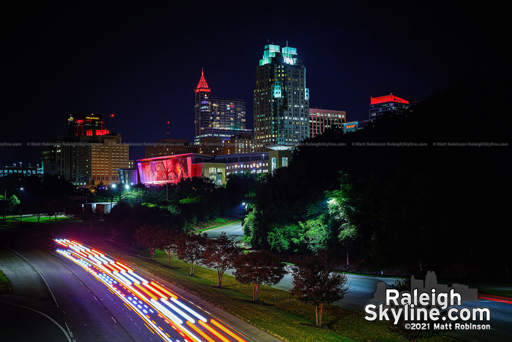 Emergency vehicle passes the Raleigh skyline lit red for the Carolina Hurricanes