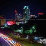 Emergency vehicle passes the Raleigh skyline lit red for the Carolina Hurricanes