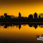 Downtown Raleigh skyline mirrored in a puddle at sunrise