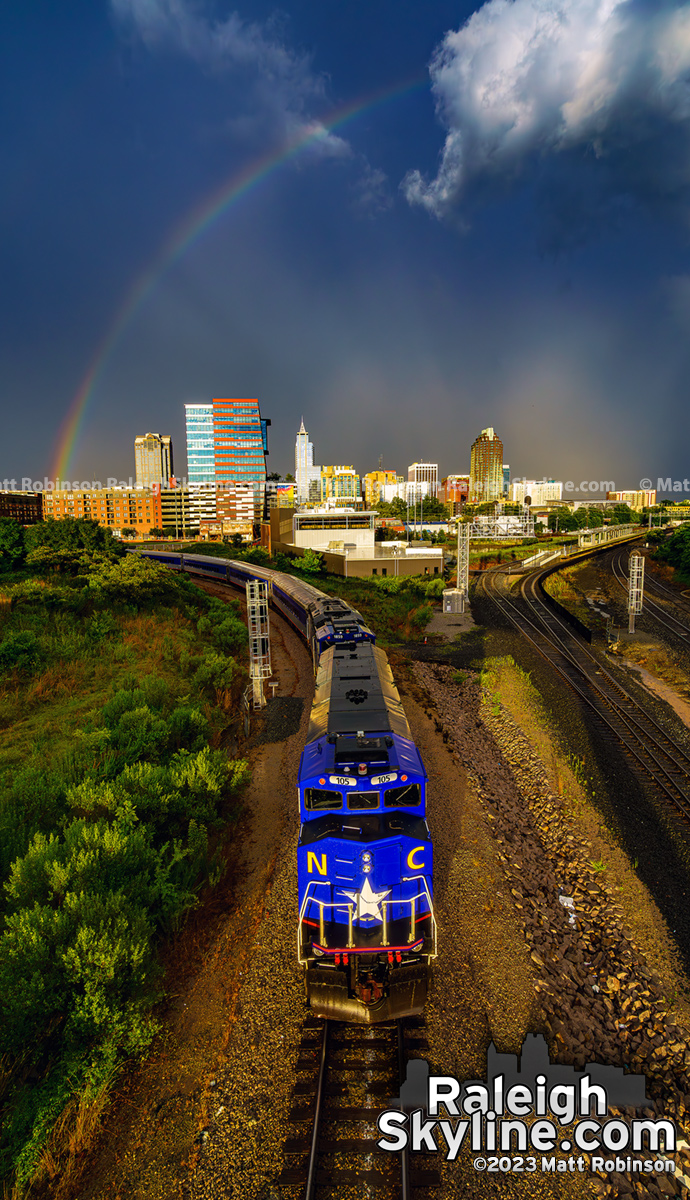 NCDOT Locomotive with downtown Raleigh and rainbow over the city